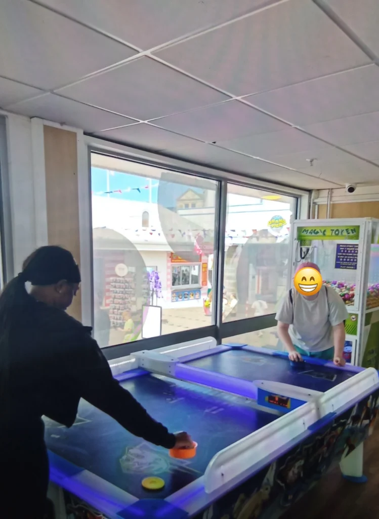 The YP is playing Air Hockey against Staff at the grand pier arcade.