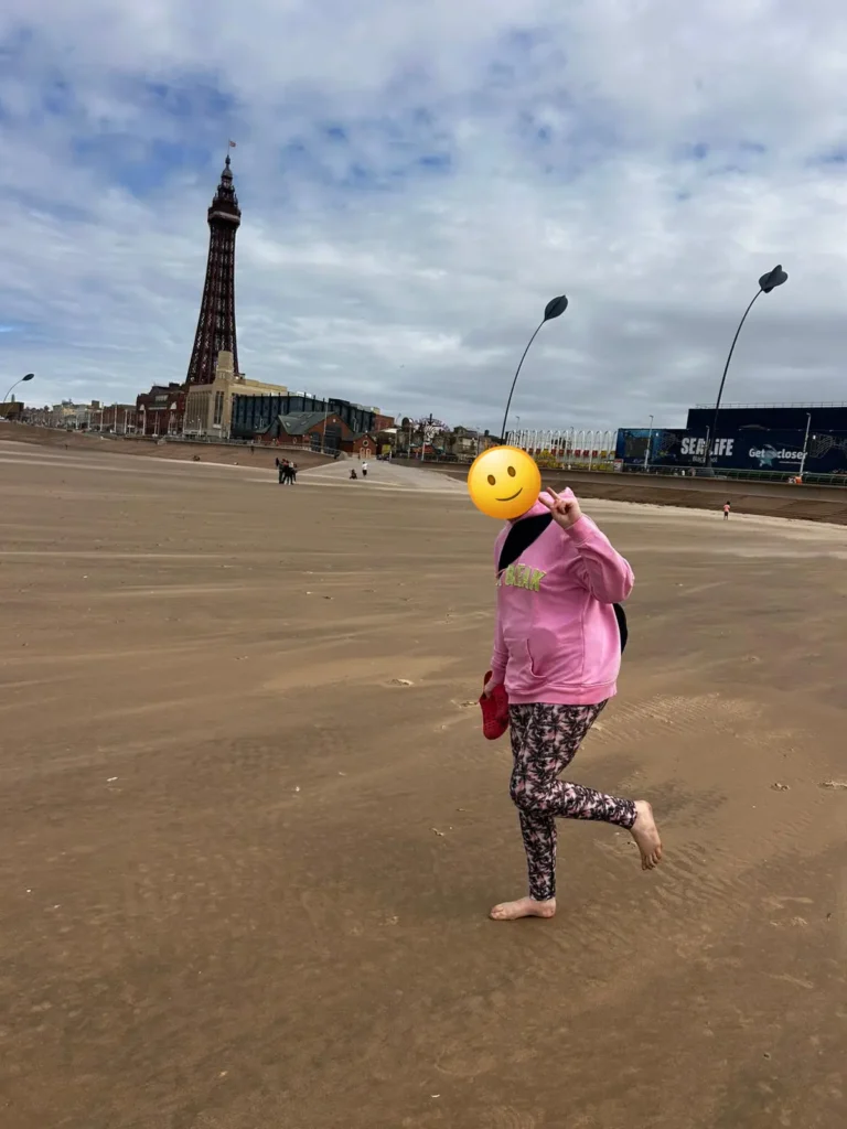 YP posing next to the Blackpool tower on the beach.