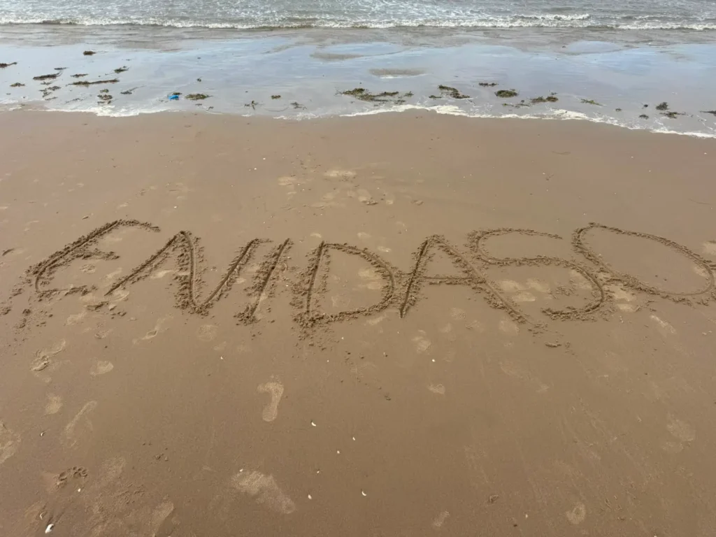 YP writing Enidaso on the sand in Blackpool.