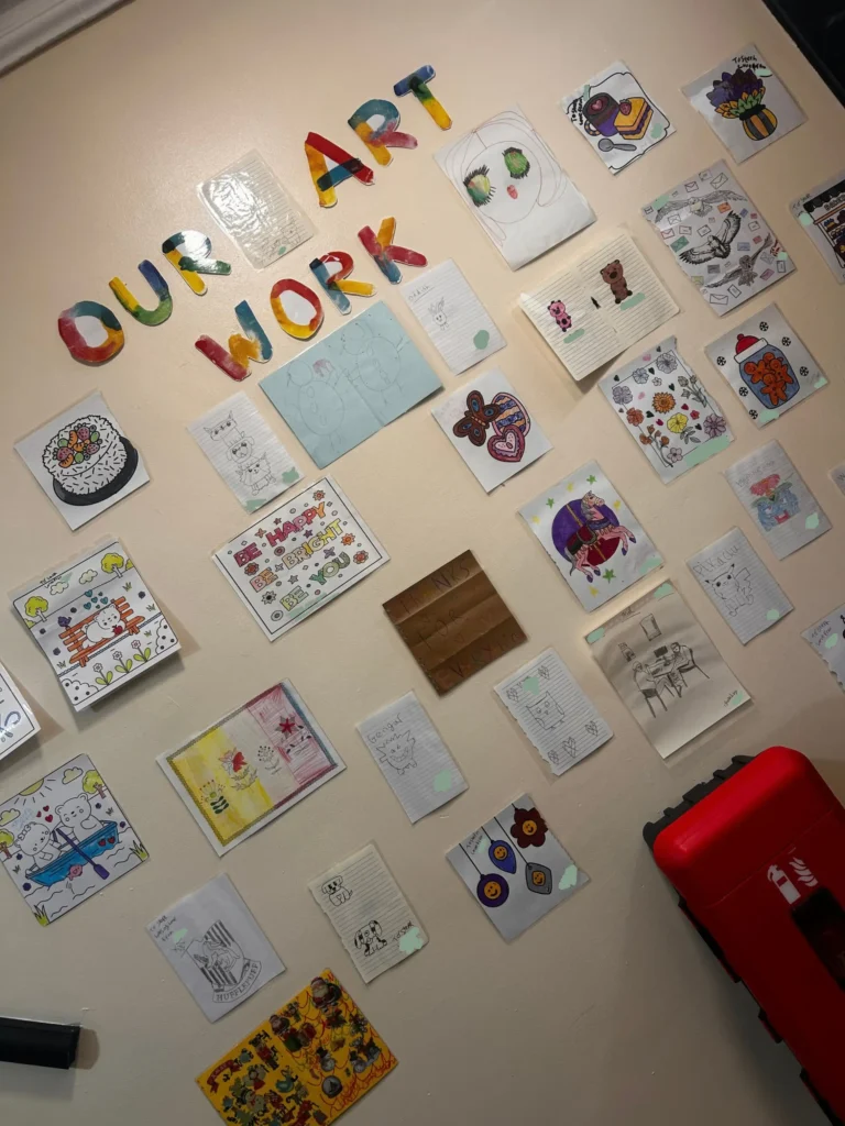 Colourful art wall displaying creative artwork and drawings completed by young people.