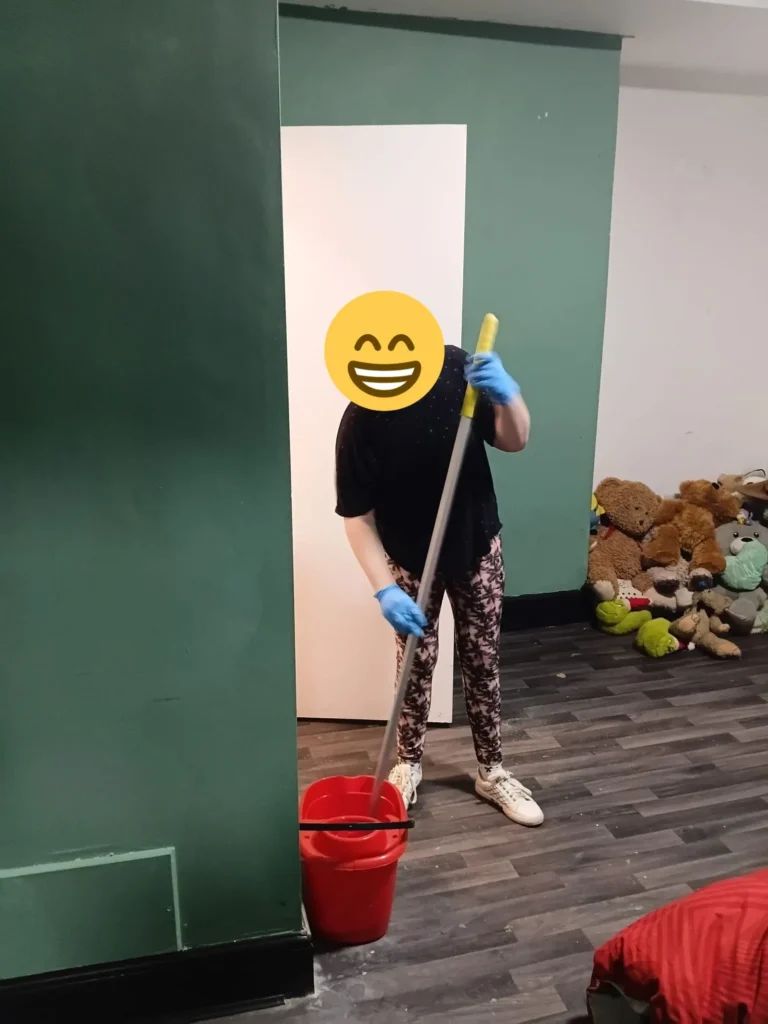 Young person cleaning and organising a bedroom independently.