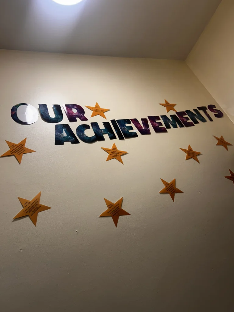 Achievements wall featuring stars and displays celebrating young people's accomplishments.