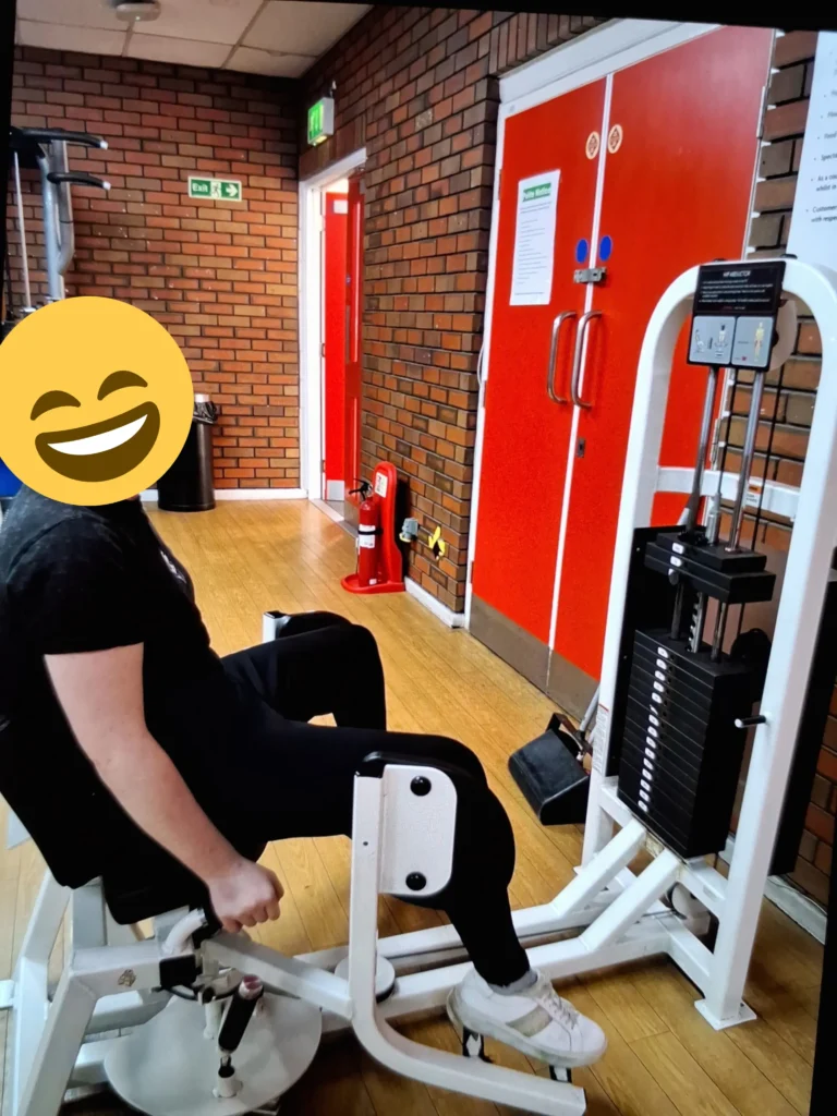 Young person using gym resistance equipment to improve strength and physical wellbeing.