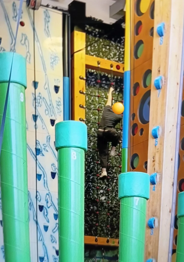 Individual taking part in a Clip ’n Climb rope climbing challenge, building confidence and staying active in the community.